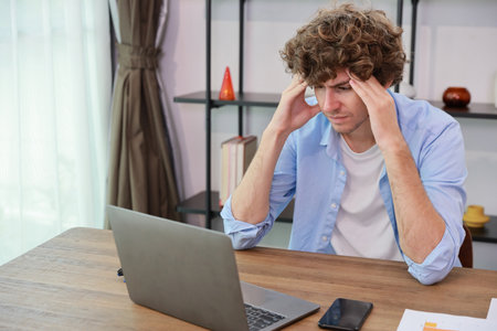 Young adult businesswoman touching his head on table in office after bad news business failure or get fired and feeling discouraged, distraught and hopeless in modern office.の写真素材