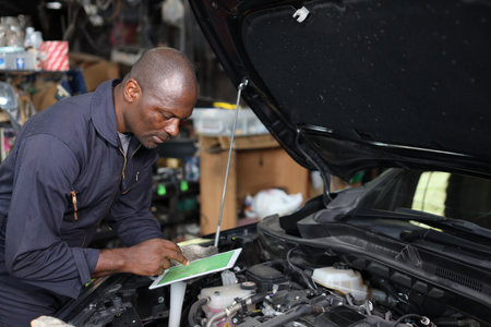 Woman technician car mechanic in uniform checking maintenance a car service with tablet at repair garage station. 
Car repair service conceptの写真素材