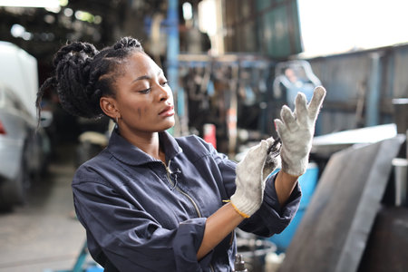 Woman technician car mechanic in uniform checking maintenance car service at repair garage station. Worker holding wrench fixing breakdown vehicle. Concept of car center repair service.の写真素材