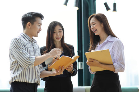 Collaborative process of young asian business people team working together discussing, researching,...