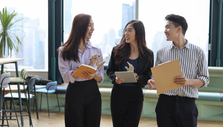 Collaborative process of young asian business people team working together discussing, researching, brainstorming and planning work at business meeting in modern office building and city backgroundの写真素材
