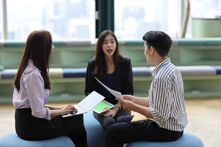 Collaborative process of young asian business people team working together discussing, researching,...