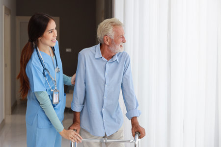 Happy caregiver helping senior old man walking with walking frame stand up from bedroom at home or retirement house.
Asian smiling nurse taking good help care and support of elder patient at house.の写真素材