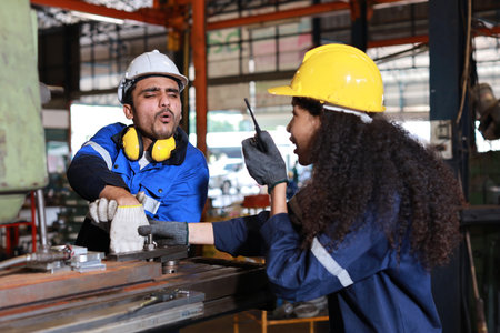 Young technician engineer or worker man in protective uniform had a hand accident on lathe machine in metal lathe factory. Safety colleague team helping him from accident. First aid training conceptの写真素材