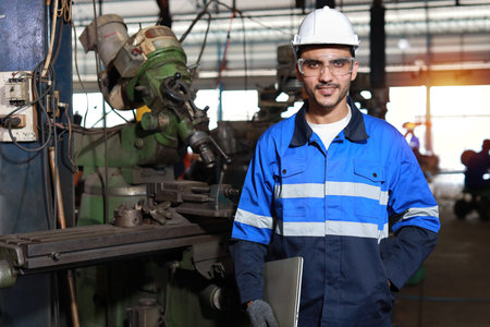 Technician engineer man in protective suit standing and using computer and looking camera while...