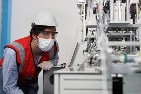 Caucasian mechanic technician maintenance, repairing industrial machinery equipment in factory....