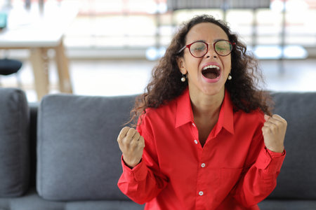 Happy woman sitting and using computer and raising hands with happy smiling face while completed business deal in living room
Businesswoman raising hands and exciting emotion with somthing successfulの写真素材