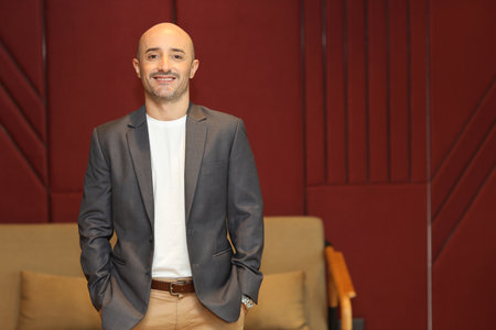 Portrait of attractive and handsome caucasian businessman in suit standing and while looking at camera with confident happy face in modern office. Success business and technology conceptの写真素材