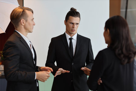 Collaborative process of multiethnic business people team working together discussing, researching, brainstorming and planning work at business meeting in modern office building and city backgroundの写真素材