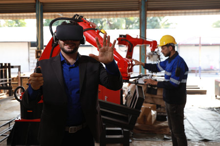 Professional heavy industry technician engineer with workwear and businessman maintenance and check part of robot arm machine with VR virtual in factory automotive. Industrial and technology conceptの写真素材