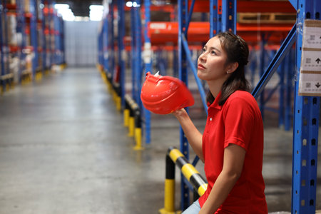Portrait of warehouse workers young asian woman sitting and taking a break while wipe the sweat away after controlling stock and inventory in retail warehouse logistics, distribution centerの写真素材