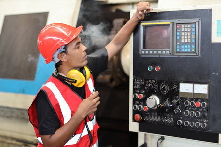 Asian technician engineer or worker man in protective uniform smoking after having lunch at industry manufacturing factoryの写真素材
