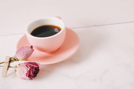 Coffee and pink dry rose on tableの写真素材