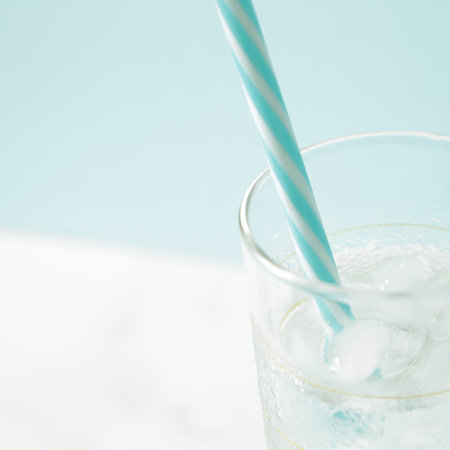 glass with ice cubes on white tableの写真素材
