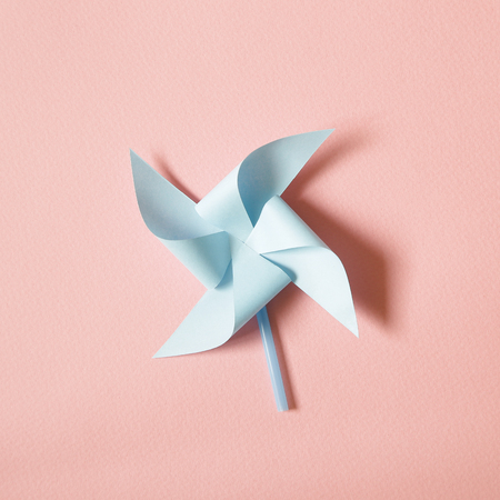 Blue paper pinwheel on pink backgroundの写真素材