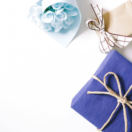 Blue gift and blue flower bouquet on white background