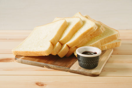 sliced plain bread and jam on wooden trayの写真素材