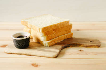 sliced plain bread and jam on wooden trayの写真素材
