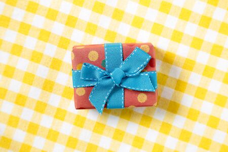 pink gift on yellow check pattern fabric backgroundの写真素材