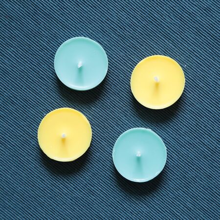 Yellow and blue candles on fabric backgroundの写真素材
