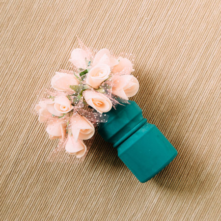 Decorative pink flower on brown fabric background