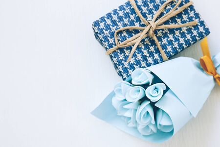 Gift and blue flower bouquet on white backgroundの写真素材