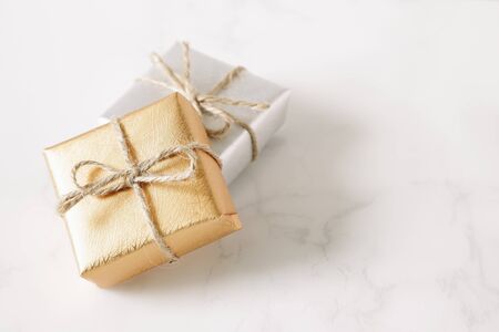 Gold and silver gift on white stone tableの写真素材