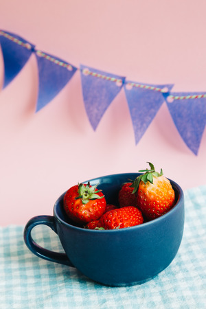 Strawberries in a cup with colorful party flagの写真素材