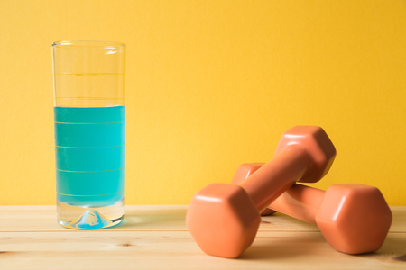 Fitness equipment dumbbells and sport energy drink on wooden table (healthy lifestyle sport object)の写真素材