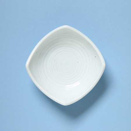 Light blue dish isolated on blue backgroundの写真素材