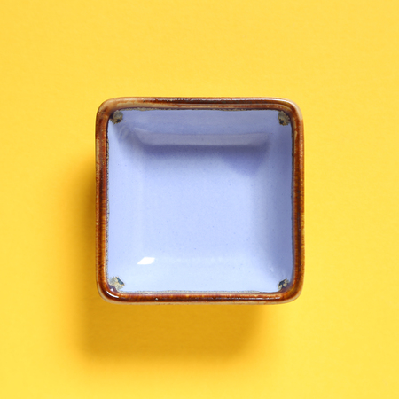 Light purple dish isolated on yellow backgroundの写真素材