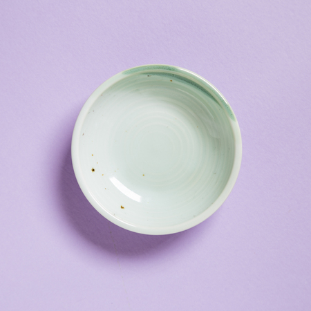 Green dish isolated on purple backgroundの写真素材
