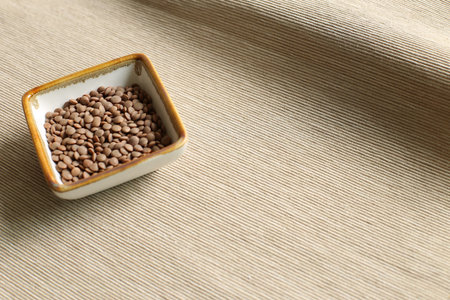 Healthy food Lentils in a bowl on beige fabric background