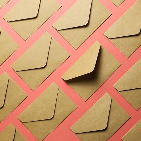 Kraft brown paper envelopes on pink backgroundの写真素材