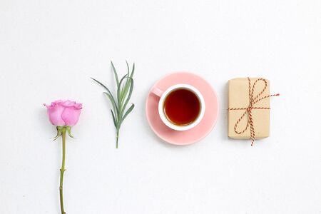 Pink purple rose flower and black tea, gift box on white background. flat lay, top view, copy spaceの写真素材