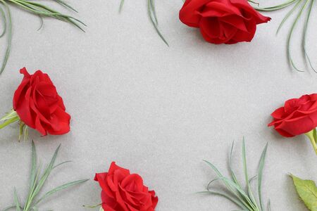 Red rose flowers on gray background. Floral composition, flat lay, top view, copy spaceの写真素材