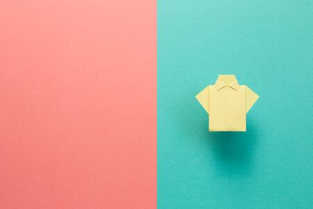 Yellow paper shirt origami on green pink backgroundの写真素材