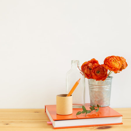 Work and study place. note book, pencil with floral decoration on wooden desk with white background.