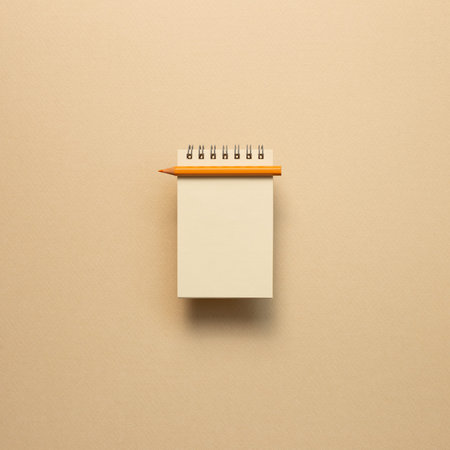 Empty kraft notepad with colored pencil on beige background. top viewの写真素材