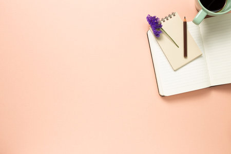 Work and study place. notebook and cup of coffee on pink background. flat lay, top view