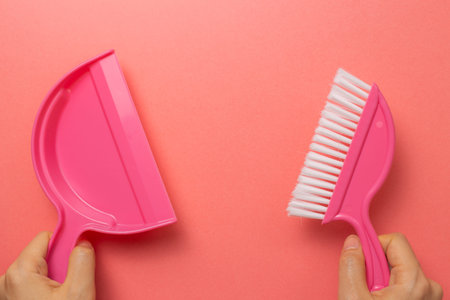 Pink broom and dustpan isolated on pink background. top viewの写真素材