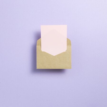 Kraft envelope and empty card on light purple background. top view, copy spaceの写真素材