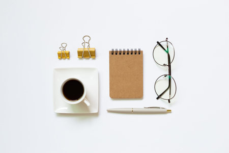 Notebook, pen, cup of coffee, glasses, clip on white background. Work and study place. flat lay, top...
