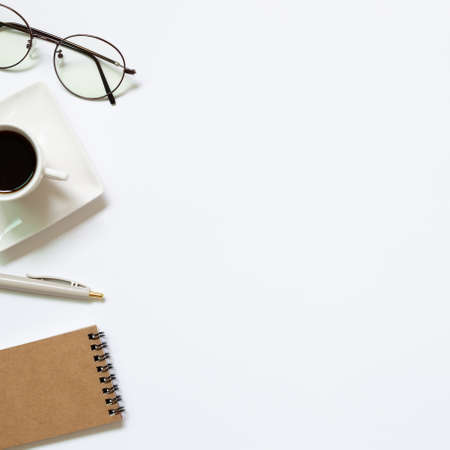 Notebook, pen, cup of coffee, glasses on white background. Work and study place. flat lay, top view, copy spaceの写真素材