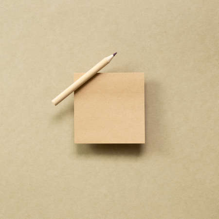 Memo note pad with wooden pencil on brown kraft paper background. top view, copy spaceの写真素材