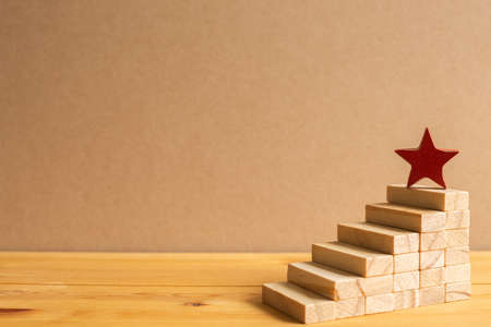 Red star on wood block stairs with brown background. Business development, growth, success concept. with copy spaceの写真素材