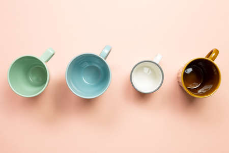 Colorful empty mug cups on pink background. top viewの写真素材
