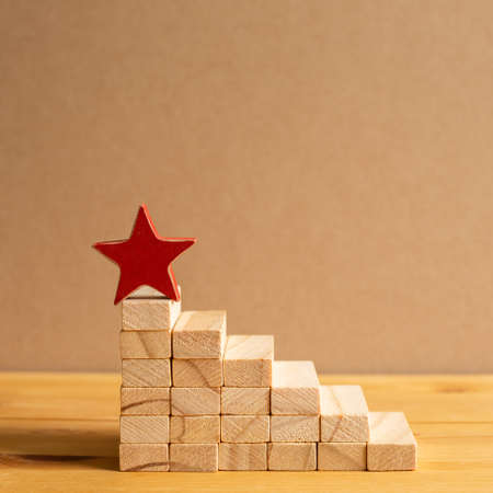 Red star on wood block stairs with brown background. Business development, growth, success concept. with copy spaceの写真素材