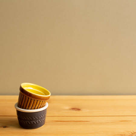 Stack of ceramic bowls on wooden table with brown backgroundの写真素材
