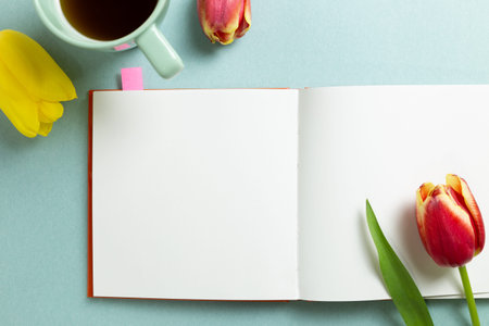 Empty note paper with tulip flowers, black coffee on mint green background. flat lay, top view, copy...
